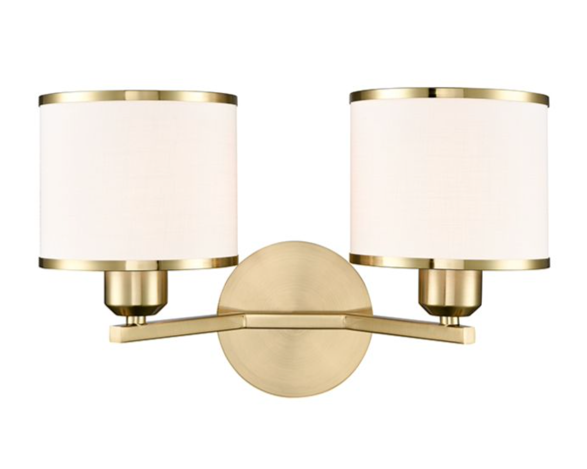A modern two-light wall sconce with cylindrical white fabric shades and a brushed brass-finished metal body, shown against a plain white background.