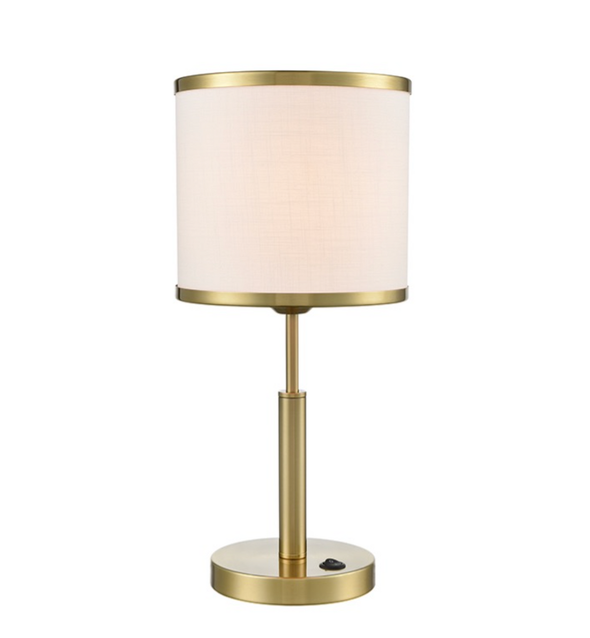 A modern table lamp with a cylindrical drum shade in a warm off-white fabric, framed by brushed gold metal trim at the top and bottom. The lamp has a slim gold metal stem and a round base with a visible power switch.